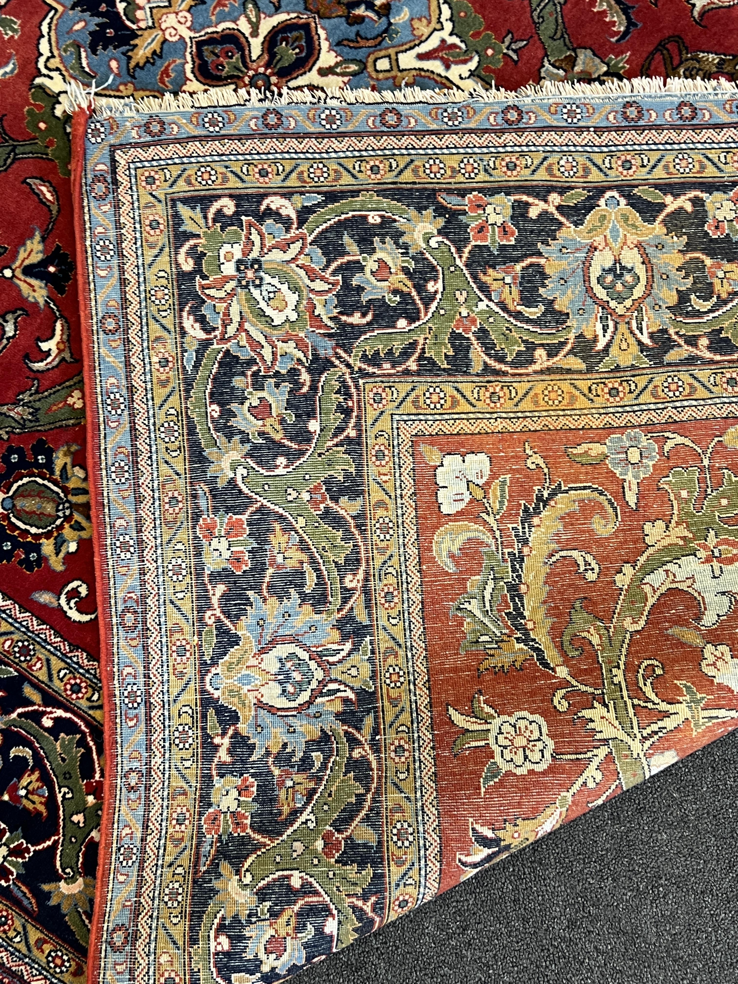 A Kashan red ground rug, woven with scrolling foliage and birds within a dark border, 216 x 138cm. Condition - good